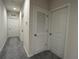 Hallway featuring three white doors, neutral paint, and plush gray carpet at 1508 Figleaf Ln, Clearwater, FL 33756