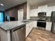 Modern kitchen featuring white cabinets, stainless steel appliances, granite counters and sleek hardwood floors at 1508 Figleaf Ln, Clearwater, FL 33756
