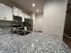 Bright kitchen with white cabinets, stainless steel appliances, granite counters and view of doorway at 1508 Figleaf Ln, Clearwater, FL 33756