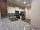 Bright kitchen featuring white cabinets, stainless steel appliances and granite counters with brick accent wall at 1508 Figleaf Ln, Clearwater, FL 33756