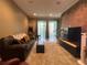 Cozy living room with brick accent wall, stylish furniture, and access to screened patio at 1508 Figleaf Ln, Clearwater, FL 33756