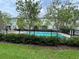 Community pool featuring mature trees, landscaping, buildings, and fencing at 1508 Figleaf Ln, Clearwater, FL 33756