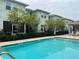 Community pool featuring a paved deck, buildings, trees, and fencing at 1508 Figleaf Ln, Clearwater, FL 33756