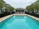 Community pool featuring a pool house, mature trees, buildings, and fencing at 1508 Figleaf Ln, Clearwater, FL 33756