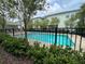Community pool featuring mature trees, landscaping, buildings, and fencing at 1508 Figleaf Ln, Clearwater, FL 33756