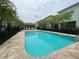 Community pool featuring a paved deck, buildings, trees, and fencing at 1508 Figleaf Ln, Clearwater, FL 33756