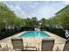 Community pool featuring lounge chairs, mature trees, and fencing at 1508 Figleaf Ln, Clearwater, FL 33756
