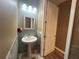 Stylish powder room with pedestal sink, decorative mirror and neutral paint color at 1508 Figleaf Ln, Clearwater, FL 33756