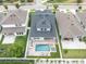 Aerial view of the home with a pool, hot tub, and well-maintained backyard, nestled among neighboring houses at 15241 Caravan Ave, Odessa, FL 33556