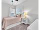 Cozy bedroom with a pink bed, neutral walls, and natural light from the window creating a peaceful retreat at 15241 Caravan Ave, Odessa, FL 33556
