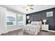 A beautifully styled bedroom with a large black accent wall, a large window, and natural light at 15241 Caravan Ave, Odessa, FL 33556