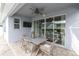 Cozy covered patio featuring a ceiling fan, TV, and outdoor dining set for relaxing and entertaining at 15241 Caravan Ave, Odessa, FL 33556