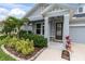 Close up of the front of a home, landscaped with plants and a lawn at 15241 Caravan Ave, Odessa, FL 33556