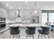 Bright, modern kitchen features gray cabinets, a stainless steel fridge, and a white quartz countertop island with seating at 15241 Caravan Ave, Odessa, FL 33556