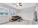 Comfortable living room featuring a leather couch, contemporary ceiling fan, and bright, natural light from two windows at 15241 Caravan Ave, Odessa, FL 33556