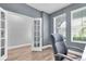 Home office showcasing an open glass door entrance and wood flooring along with a comfy office chair at 15241 Caravan Ave, Odessa, FL 33556