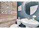 Stylish powder room with accent wall, vessel sink, modern faucet, and decorative elements at 15241 Caravan Ave, Odessa, FL 33556