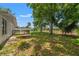 The spacious backyard includes a small wooden deck, a mix of grass and bare ground, and mature trees at 16018 Adobe Dr, Hudson, FL 34667