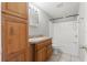 Bathroom with hardwood cabinetry, tile floors and a shower-tub combo at 16018 Adobe Dr, Hudson, FL 34667