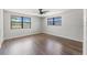 Bedroom with two windows, ceiling fan and hardwood flooring at 16018 Adobe Dr, Hudson, FL 34667