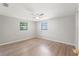 Bedroom with hardwood flooring, ceiling fan and two windows overlooking the exterior at 16018 Adobe Dr, Hudson, FL 34667