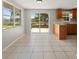 Bright kitchen with tile flooring, wood cabinets, and sliding glass doors to the deck at 16018 Adobe Dr, Hudson, FL 34667