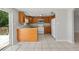 Traditional kitchen features tile flooring, wood cabinets, and modern white appliances at 16018 Adobe Dr, Hudson, FL 34667