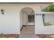 Inviting front porch with textured tile, archway, and decorative lighting at 16018 Adobe Dr, Hudson, FL 34667