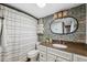 Stylish bathroom with floral wallpaper, granite countertop vanity, and unique lighting fixtures at 1602 Beachway Ln, Odessa, FL 33556