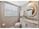 Bright bathroom with a marble vanity, framed mirror, and neutral color scheme at 1602 Beachway Ln, Odessa, FL 33556