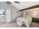 Serene bedroom with high ceilings, beam accent, and access to a private lake view balcony at 1602 Beachway Ln, Odessa, FL 33556