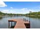 Lake view featuring a private dock with room to walk out into the water on a clear, sunny day at 1602 Beachway Ln, Odessa, FL 33556