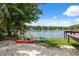 Sandy beach with kayaks by a calm lake and a private dock, under a clear blue sky at 1602 Beachway Ln, Odessa, FL 33556