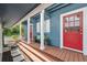 Inviting front porch with wood floors, red doors, white columns, offering a charming entrance to the home at 1602 Beachway Ln, Odessa, FL 33556