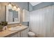Cozy bathroom featuring single sink vanity, decorative mirror and shower with curtain at 1623 Crossvine Ct, New Port Richey, FL 34655