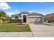Attractive single-story home featuring a manicured lawn, decorative fountain, and a two-car garage at 1623 Crossvine Ct, New Port Richey, FL 34655