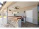 Outdoor kitchen with built in stone and tiled counter top and bar area at 1623 Crossvine Ct, New Port Richey, FL 34655