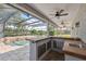 Outdoor kitchen with built in stone and tiled counter top and bar area at 1623 Crossvine Ct, New Port Richey, FL 34655