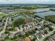 An aerial view of a home in a suburban neighborhood with ponds and green spaces at 17905 Machair Ln, Land O Lakes, FL 34638