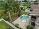 Aerial view of the backyard showcasing a private pool, lush landscaping, and neighborhood pond at 17905 Machair Ln, Land O Lakes, FL 34638