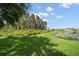 Scenic view of a lush backyard with a pond, mature trees, and a well-maintained lawn at 17905 Machair Ln, Land O Lakes, FL 34638