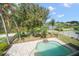 Inviting backyard features a private pool with waterfall feature, lush greenery, and views of the lake at 17905 Machair Ln, Land O Lakes, FL 34638