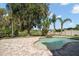 A private backyard with a freeform pool, brick patio, lush lawn, and tropical landscaping at 17905 Machair Ln, Land O Lakes, FL 34638