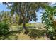 A tranquil backyard with a large tree and lush greenery provides a peaceful outdoor setting near the lake at 17905 Machair Ln, Land O Lakes, FL 34638