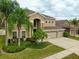 Stunning two-story home featuring a three-car garage, lush landscaping, and a welcoming front entrance at 17905 Machair Ln, Land O Lakes, FL 34638