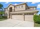 Exterior shot of a two-story home with a three-car garage and well-manicured lawn at 17905 Machair Ln, Land O Lakes, FL 34638