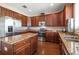 Bright kitchen featuring stainless steel appliances, dark wood cabinets, and granite countertops at 17905 Machair Ln, Land O Lakes, FL 34638