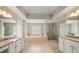 This luxurious bath features dual vanities, columns, a jetted tub, a walk-in shower, and lots of natural light at 17905 Machair Ln, Land O Lakes, FL 34638