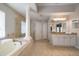 This luxurious bath features dual vanities, columns, a jetted tub, a walk-in shower, and lots of counter space at 17905 Machair Ln, Land O Lakes, FL 34638