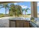 Close-up of the outdoor kitchen with a granite countertop, grill, and a lush backyard view at 17905 Machair Ln, Land O Lakes, FL 34638